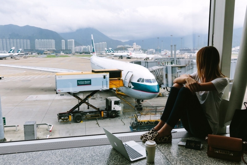 Girl at airport, looking at a plane on the tarmac